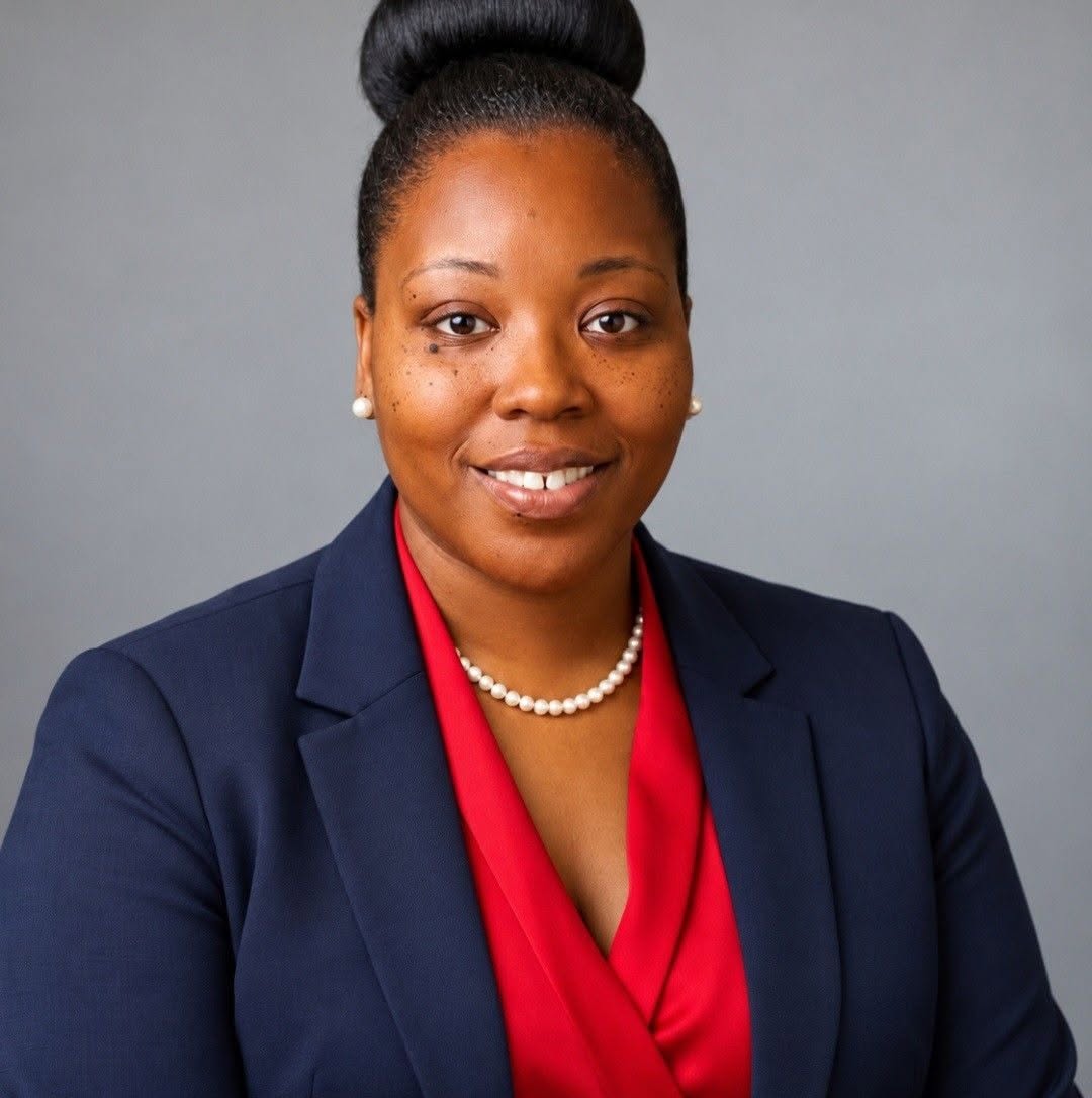 Faith P. Hill in a navy blazer and red blouse, smiling for a professional portrait.